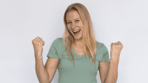 Una mujer líder de PYME, segura y sonriente, comunicándose con su equipo en un entorno moderno y luminoso. La imagen evoca confianza y conexión genuina